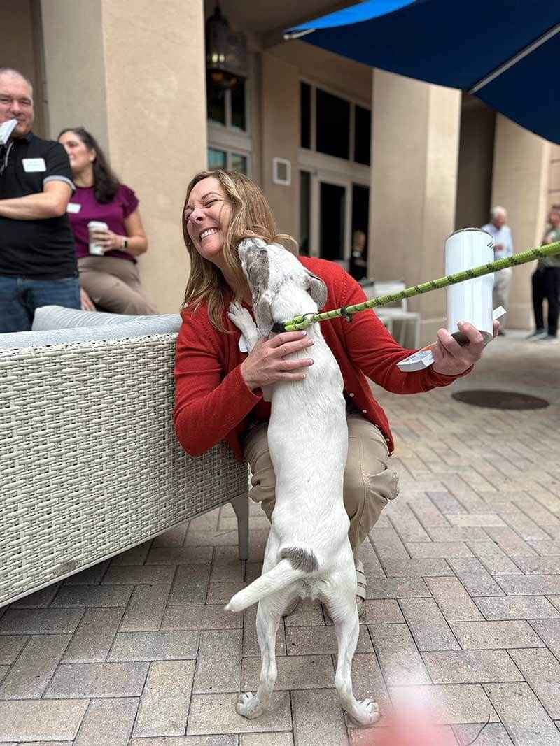 Person interacting with dog at outdoor event in Naples & Marco Island, FL courtyard