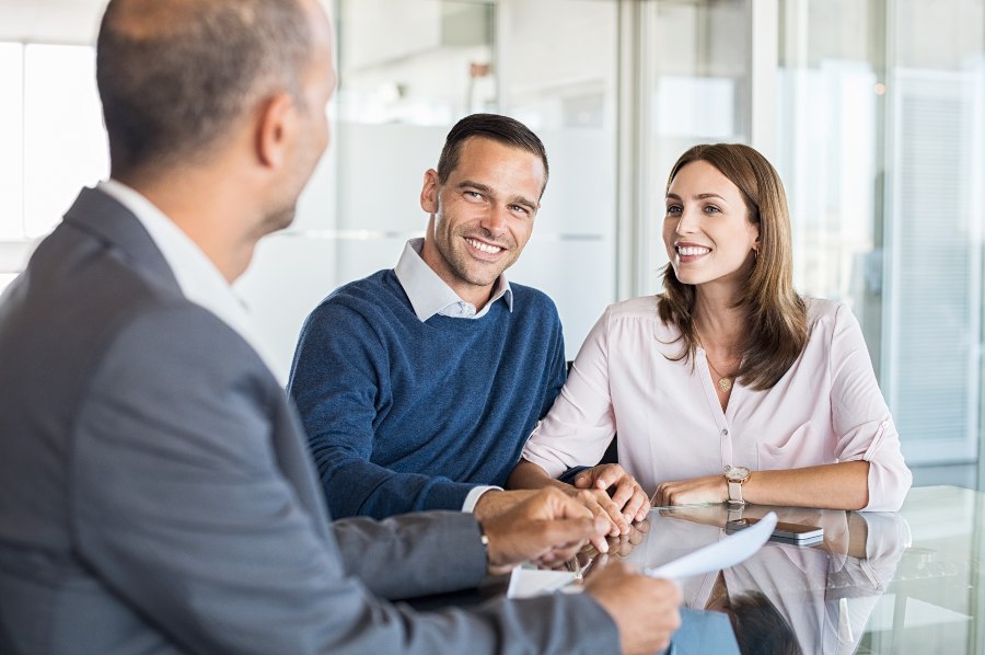 A man in suit converses with a man and a woman at The Naples Trust Company, Naples FL