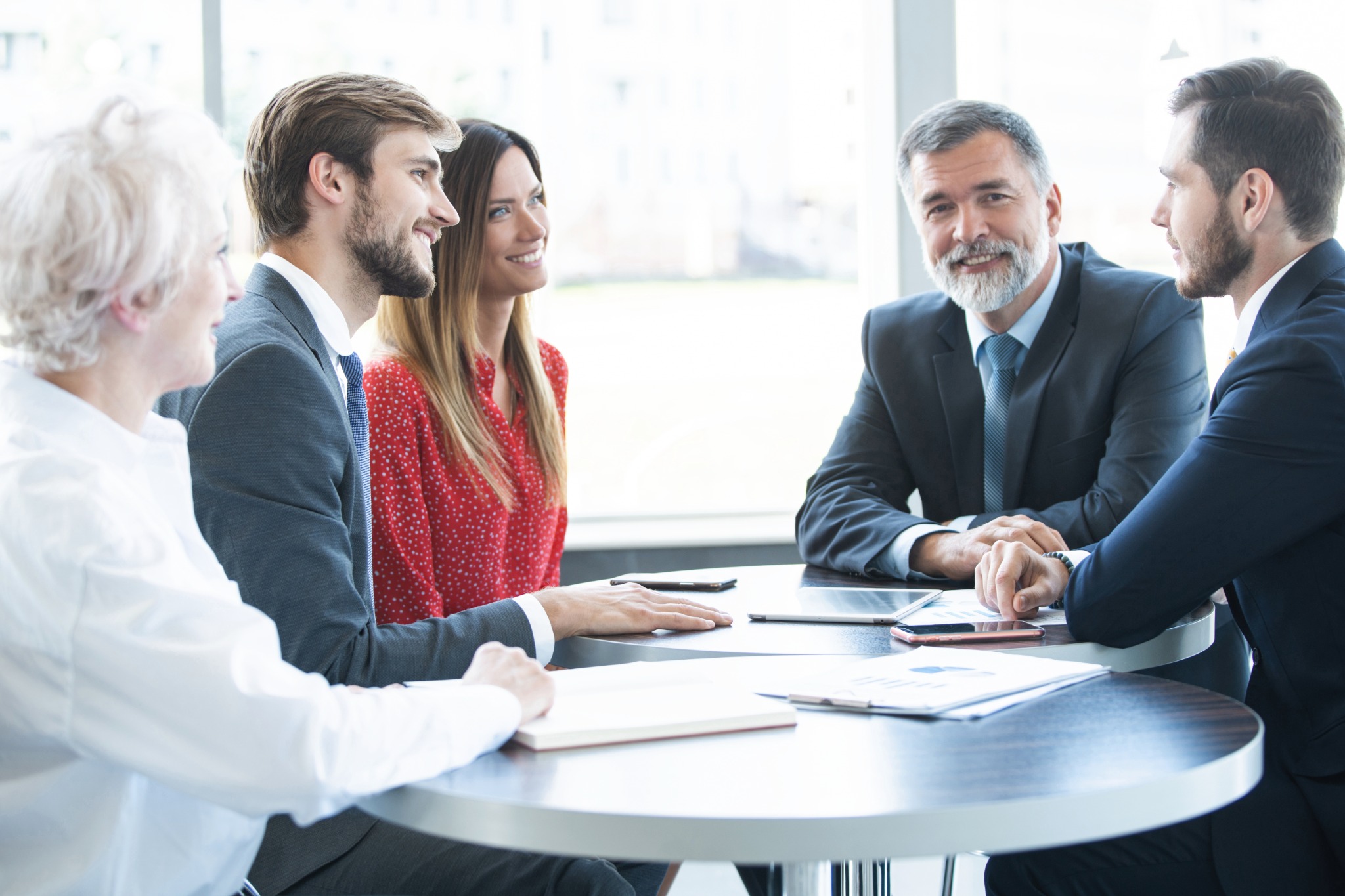 Financial advisor meeting with clients discussing wealth management and investment planning in a modern office