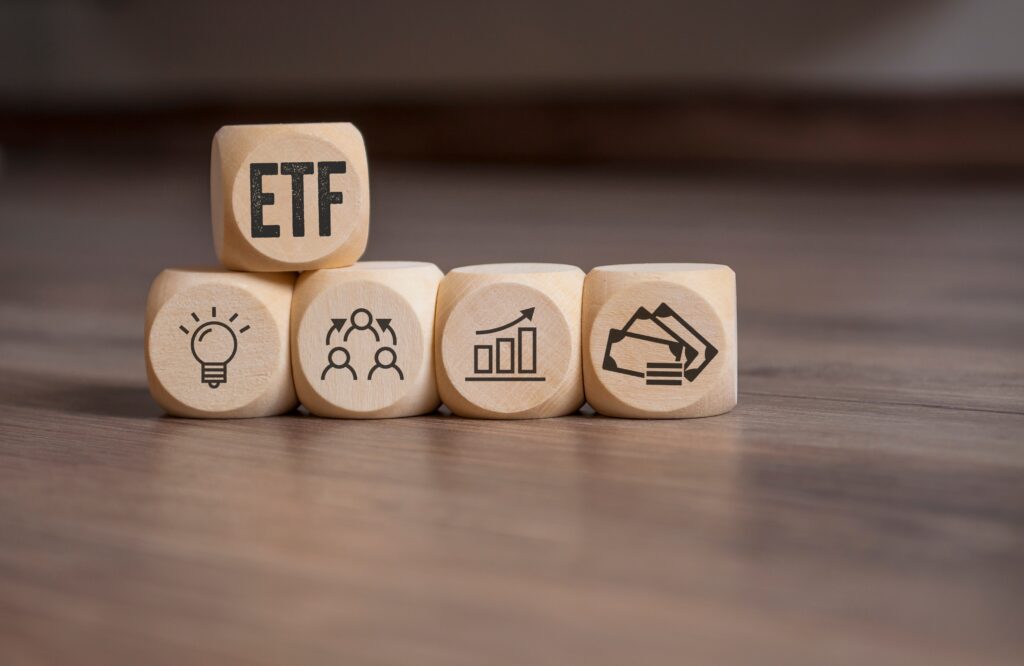 Wooden blocks showing ETF, growth chart, diversification, and money icons representing investment strategy and portfolio diversification